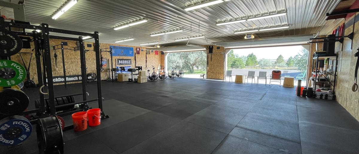 The ranch gym, rig and plates, with the door open to the pasture